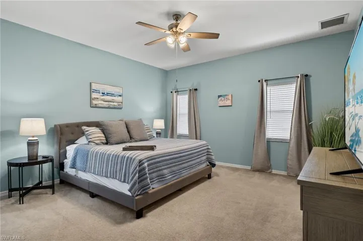 Carpeted bedroom featuring ceiling fan