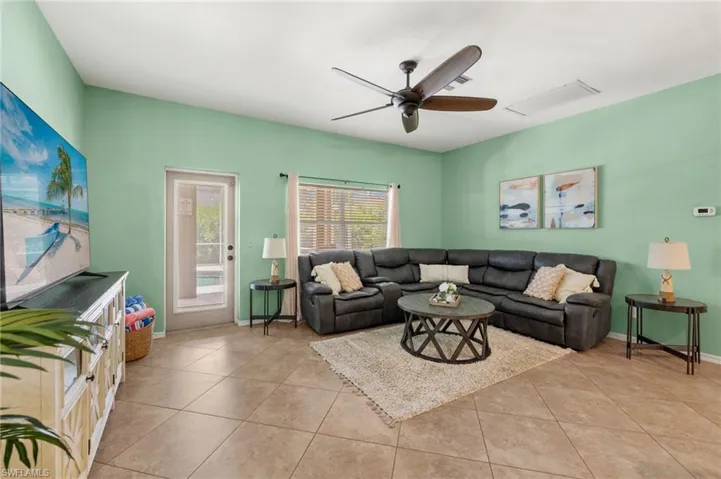 Living room featuring light tile patterned floors and ceiling fan