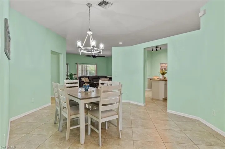 Tiled dining space with an inviting chandelier