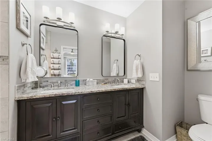Full bathroom with double vanity and light tile patterned floors