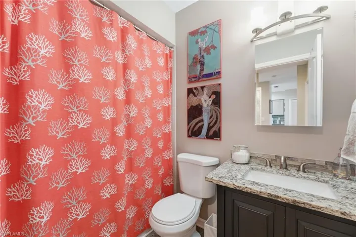 Bathroom featuring a shower with curtain and vanity