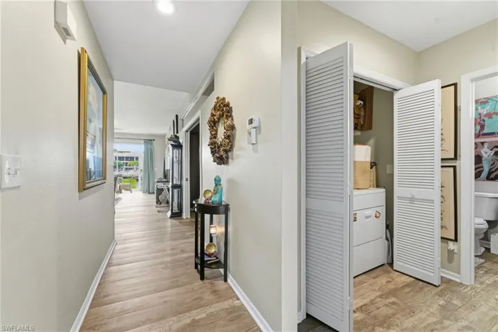 Corridor with light wood finished floors and washer / dryer