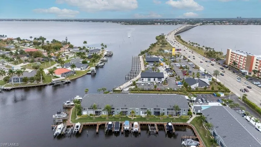 Aerial view of property and surrounding area featuring a large body of water and apartment complex