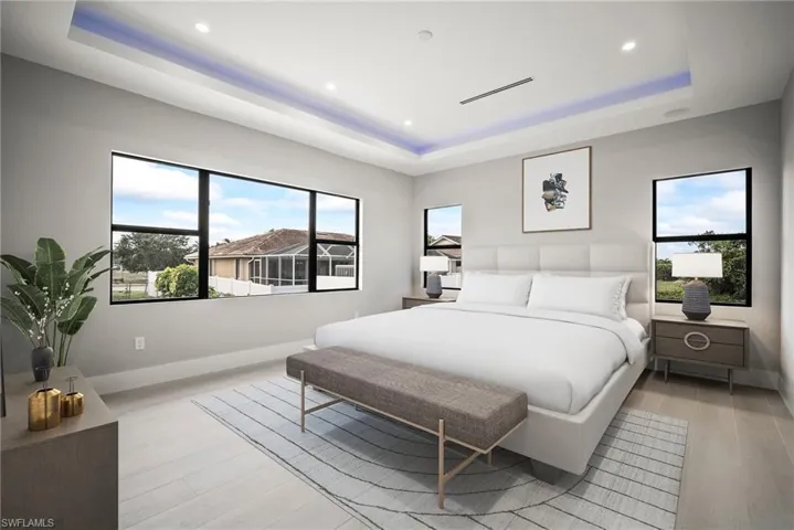 Bedroom featuring a tray ceiling, light wood-style floors, and recessed lighting