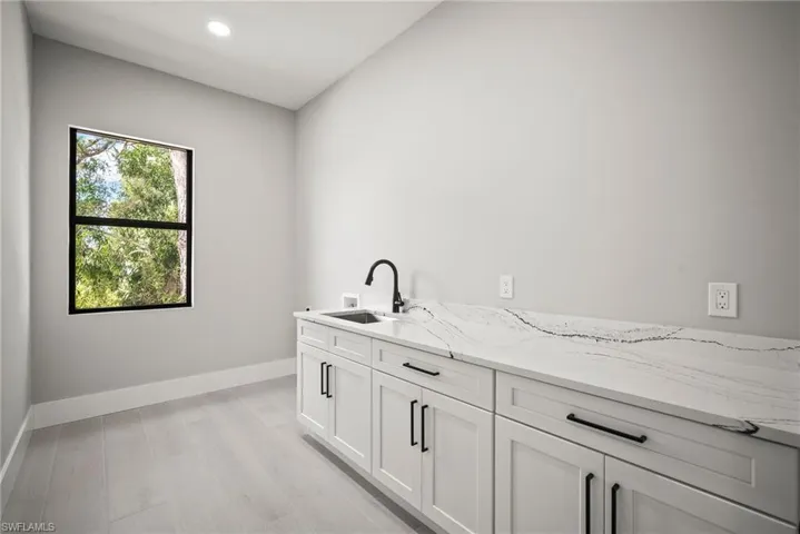 Laundry area featuring washer hookup, cabinet space, light wood finished floors, and recessed lighting
