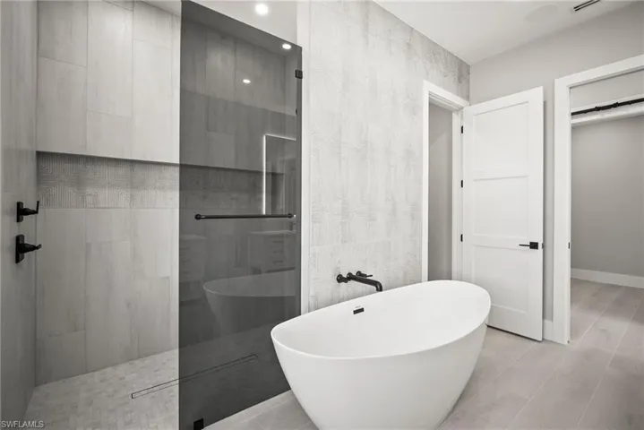 Full bathroom with a walk in shower and a soaking tub