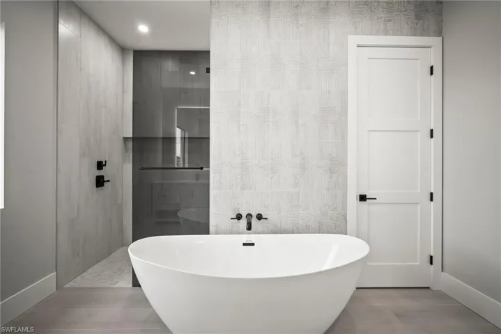 Full bath with a freestanding tub, tile walls, and walk in shower