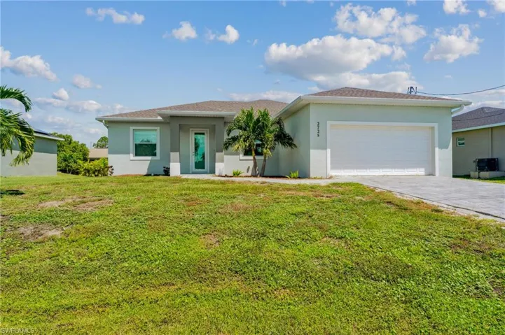 View of front of house with a garage and a front lawn