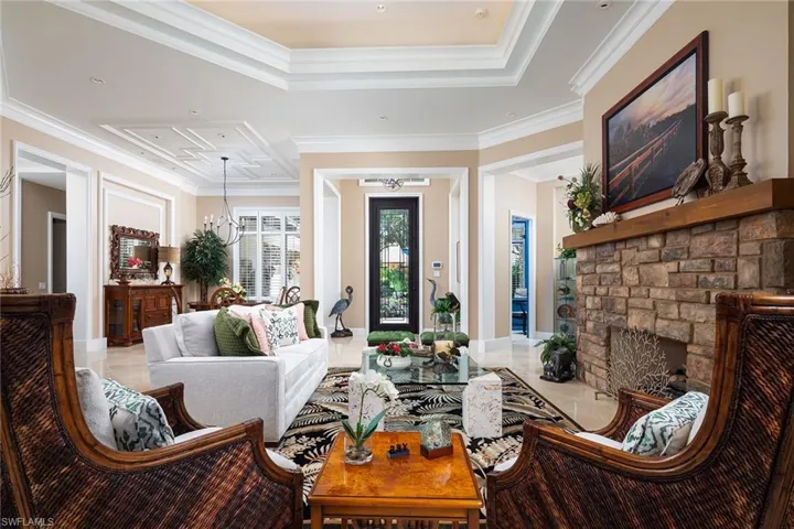 Tiled living room with a stone fireplace and ornamental molding