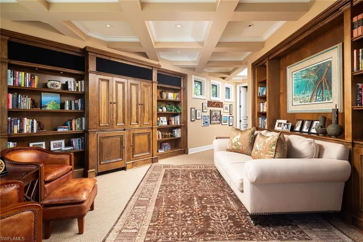 Living area with light colored carpet, built in features, coffered ceiling, and recessed lighting