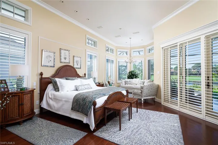 Bedroom with access to outside, a chandelier, dark wood finished floors, and ornamental molding