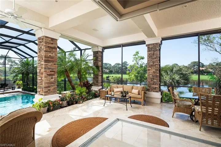 View of patio featuring a sunroom, a water view, outdoor lounge area, glass enclosure, and an outdoor pool