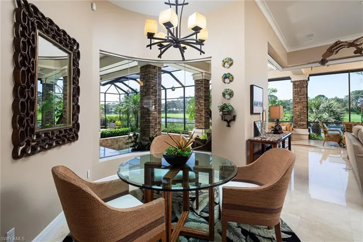 Dining area with crown molding, hanging lights, and decorative columns