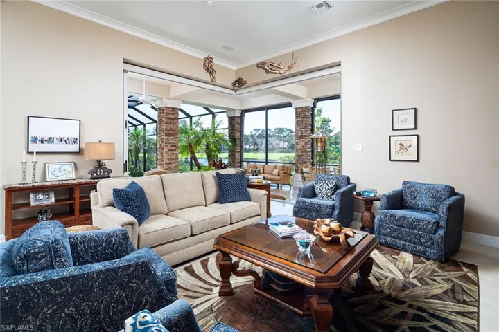 Living room featuring ornamental molding and decorative columns