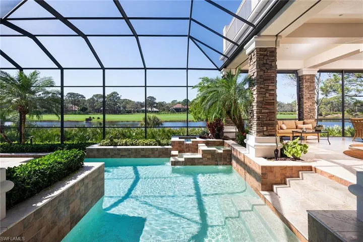 Swimming pool featuring a patio, glass enclosure, and a water view