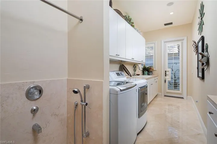 Laundry room featuring washer and clothes dryer, cabinet space, and recessed lighting