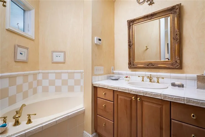Full bathroom featuring a garden tub and vanity