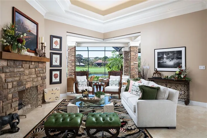 Living area with a stone fireplace and crown molding