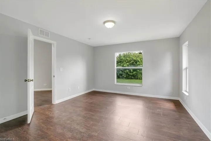 Unfurnished room with dark wood-type flooring