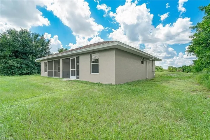 Back of property featuring a yard and a sunroom
