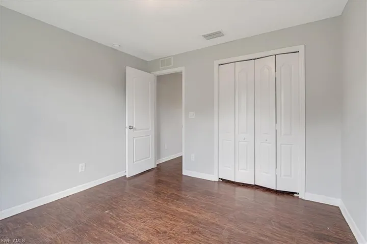 Unfurnished bedroom with a closet and dark hardwood / wood-style flooring