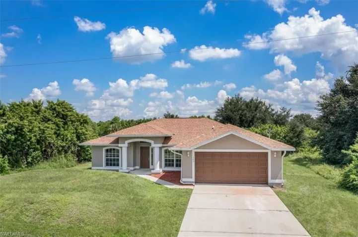 Single story home featuring a garage and a front yard