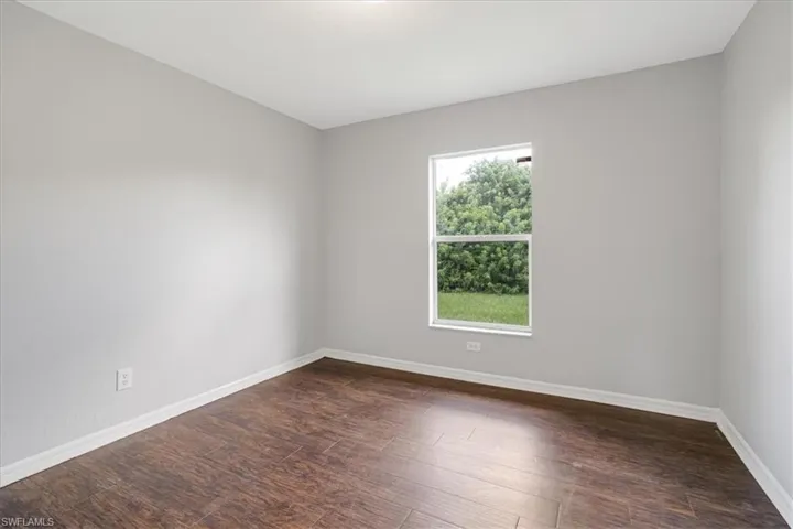 Empty room with dark wood-type flooring