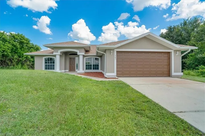 View of front facade featuring a front yard and a garage
