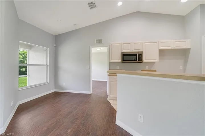 Kitchen featuring white cabinets, lofted ceiling, and dark hardwood / wood-style floors