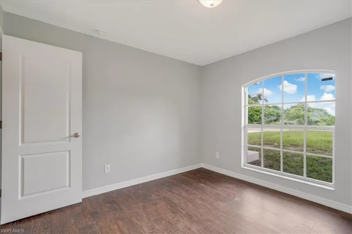 Unfurnished room with dark hardwood / wood-style floors