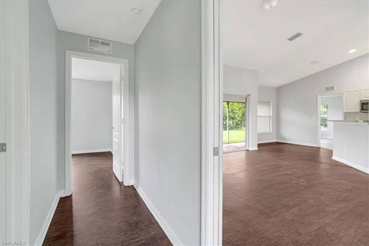 Corridor with lofted ceiling and dark wood-type flooring