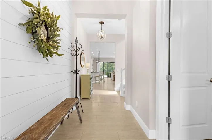 Entryway featuring shiplap accent wall, light tile flooring, and recessed lighting
