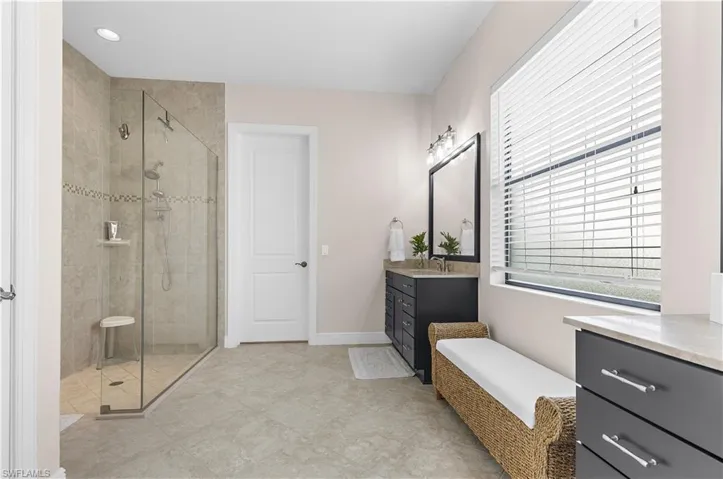 Spacious bathroom featuring a glass-enclosed shower with tiled walls and a built-in shelf