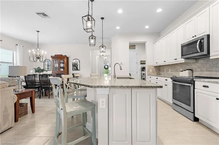 Kitchen island featuring a granite countertop with integrated sink and chrome faucet