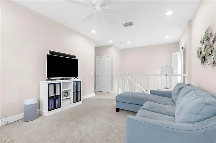 Carpeted room featuring a white ceiling fan, recessed lighting, and light-toned walls