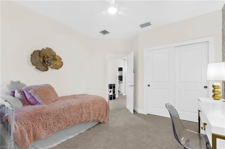 Neutral-toned room featuring a ceiling fan, light gray carpet flooring, and white baseboards