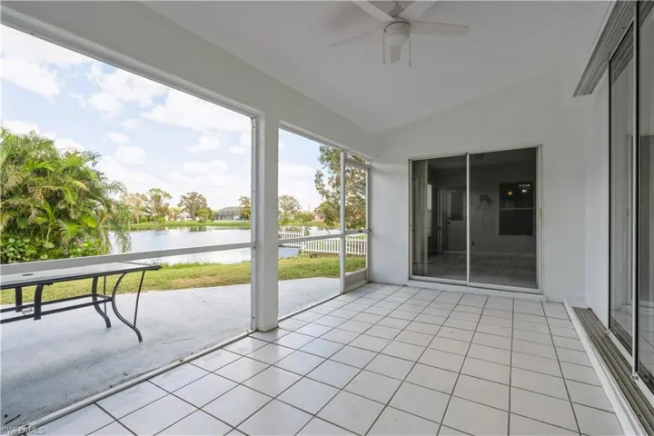 Unfurnished sunroom with lofted ceiling, a water view, and ceiling fan