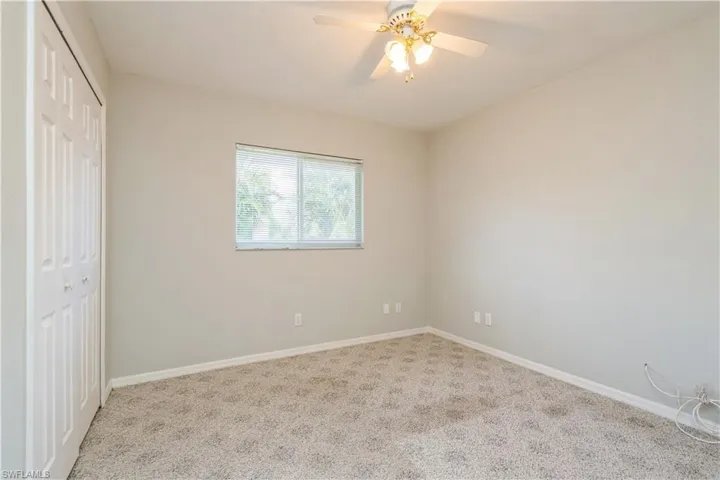 Unfurnished bedroom with a closet, ceiling fan, and light carpet