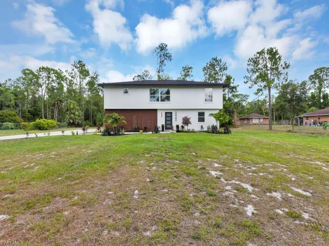 Rear view of property with a lawn