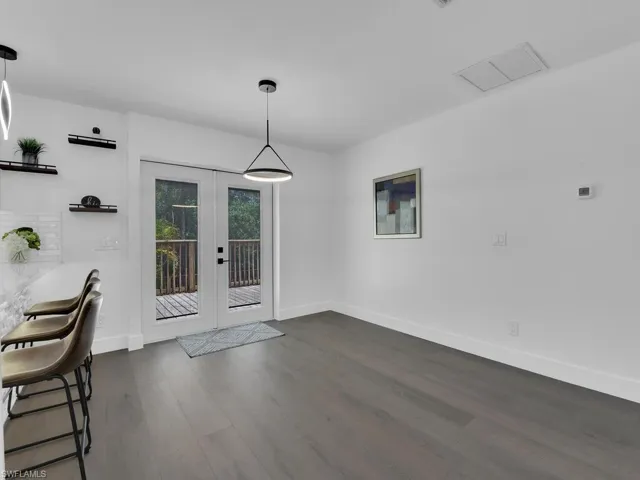 Unfurnished dining area featuring french doors and dark wood-type flooring