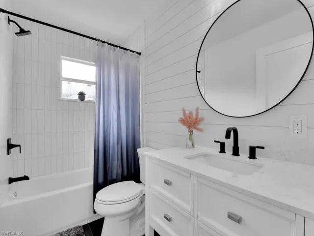Full bathroom with large vanity, toilet, and shower / tub combo with curtain