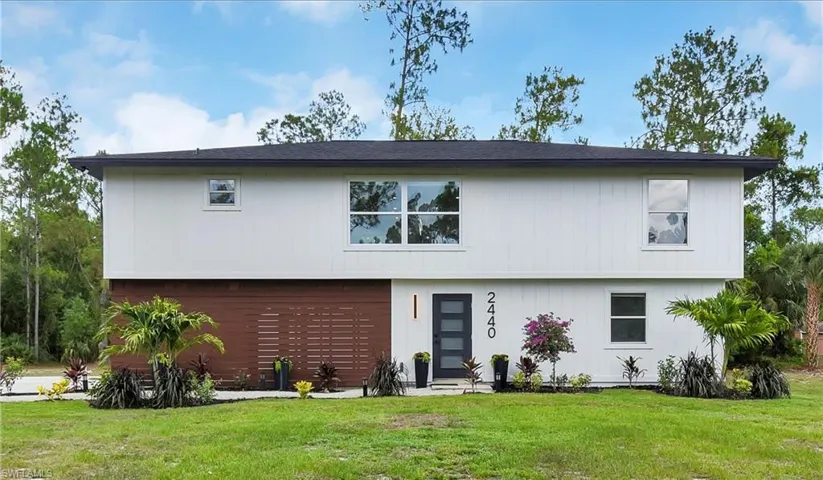 View of front of property with a garage and a front yard