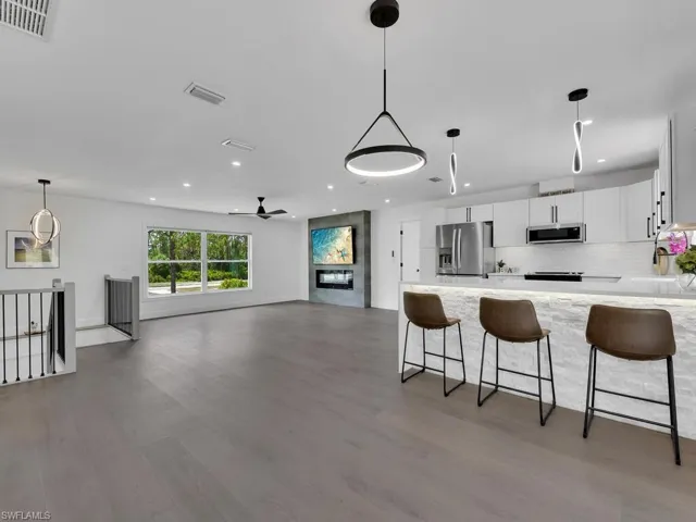 Kitchen with appliances with stainless steel finishes, white cabinets, tasteful backsplash, and hardwood / wood-style flooring