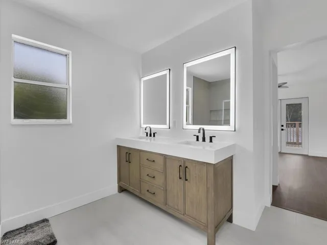 Bathroom featuring hardwood / wood-style floors, oversized vanity, and dual sinks