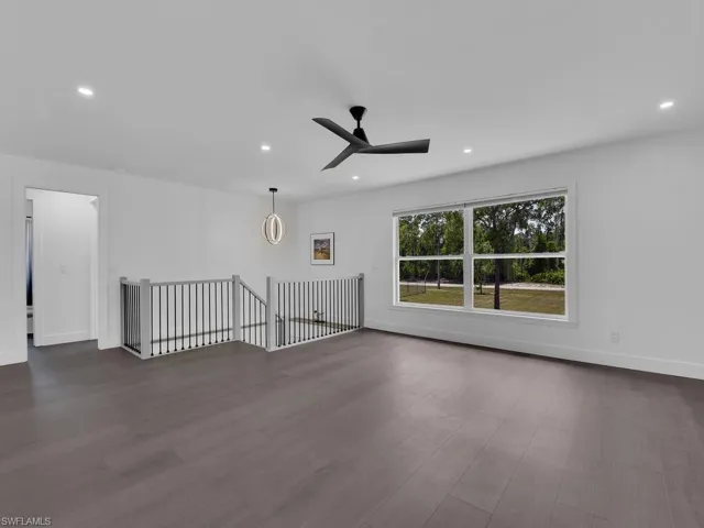 Unfurnished room with ceiling fan and dark hardwood / wood-style flooring