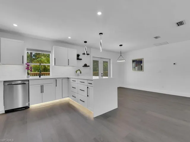 Kitchen featuring backsplash, dark wood-type flooring, and stainless steel dishwasher