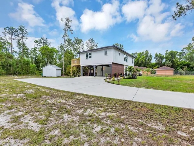 Back of property featuring a yard and a carport