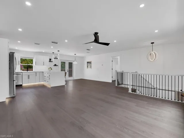Unfurnished living room featuring ceiling fan and hardwood / wood-style flooring