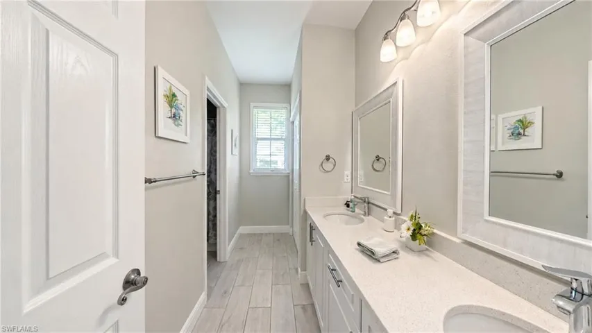 Dual vanity featuring integrated sinks, light-toned countertops, and chrome fixtures