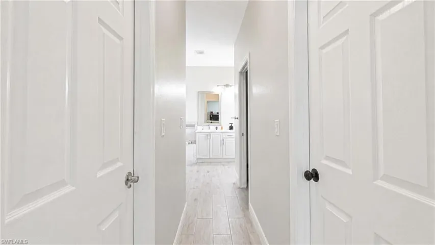 Hallway featuring neutral wall tones and wood-finish flooring